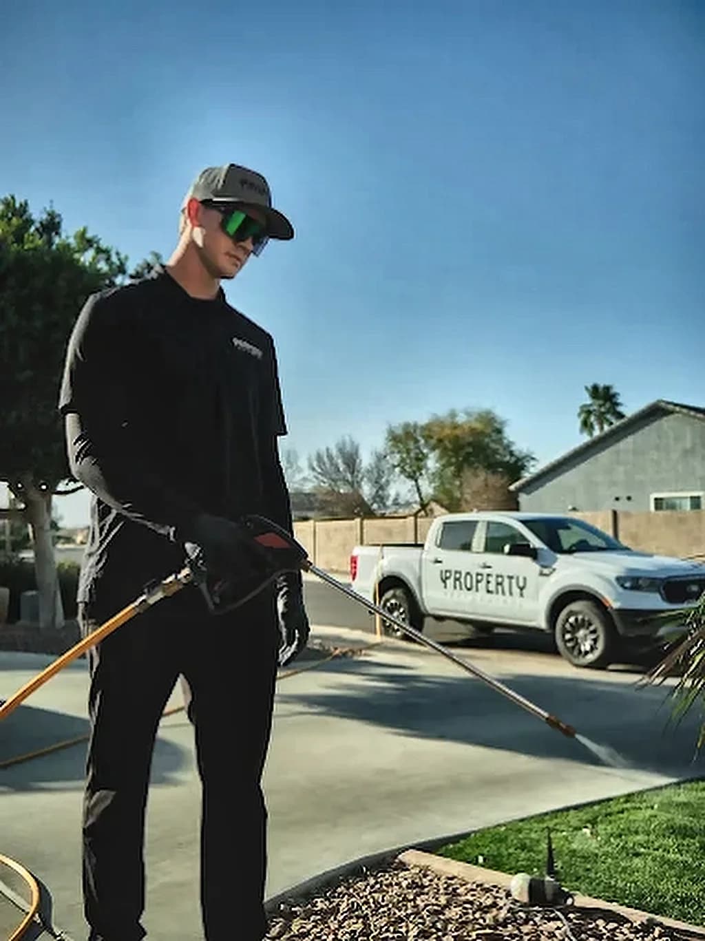 A Property Pest Control technician with a marked service truck in a Valley driveway