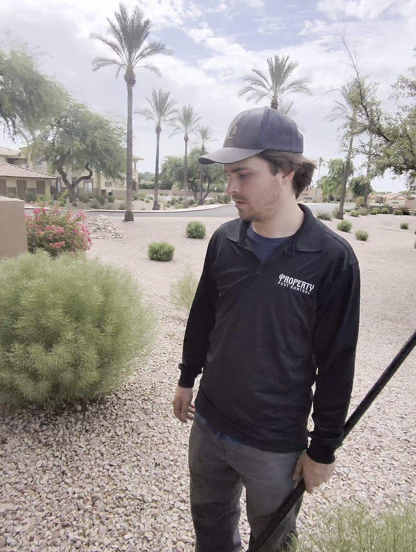 Property Pest Control technician in uniform with a spray wand