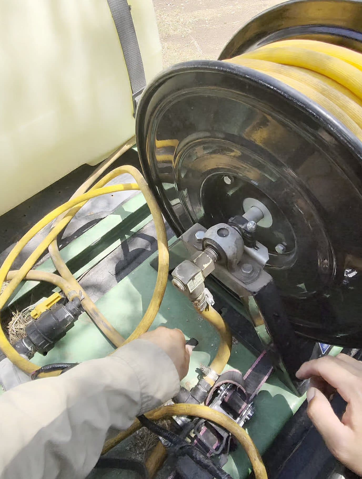 Technician operating a truck-mounted spray rig on a service call