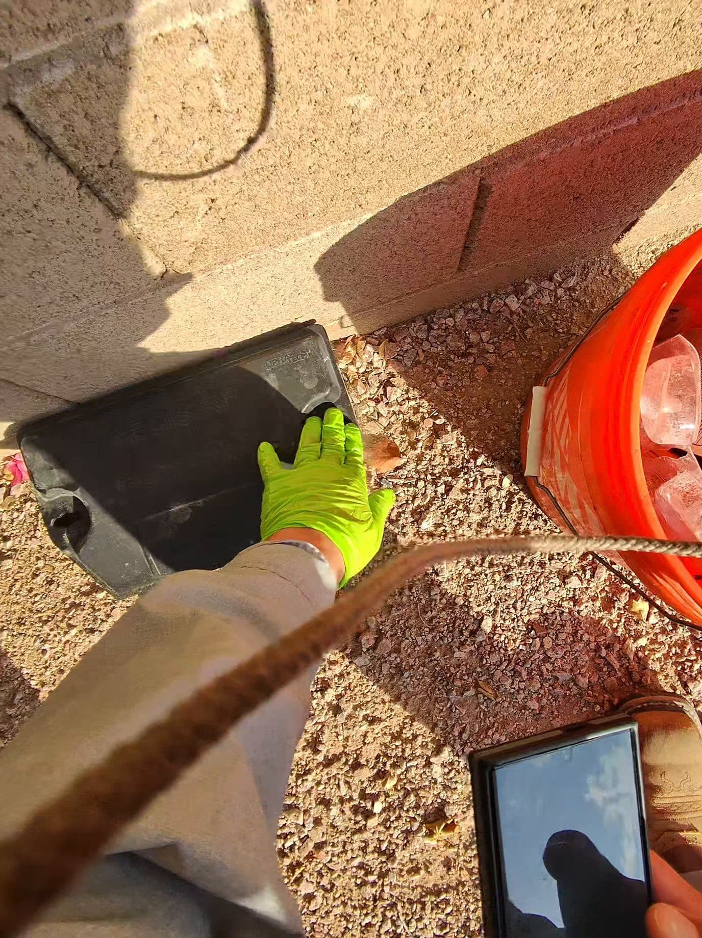 Technician servicing a tamper-resistant rodent bait station